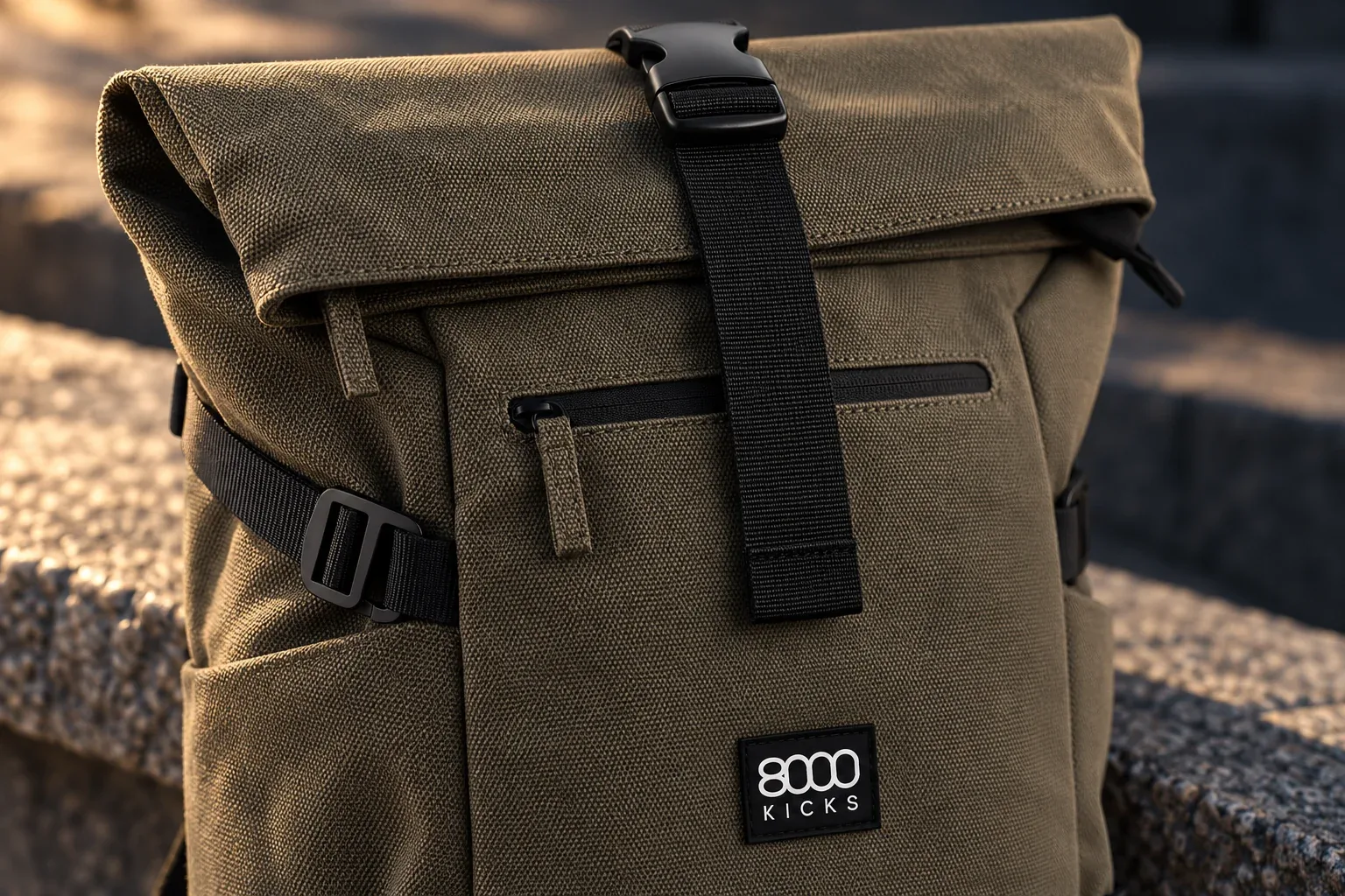 Detail tmavozelenej konopnej tkaniny Nomad Backpack, čiernej pracky rolovacieho vrchu a bočného sťahovacieho popruhu